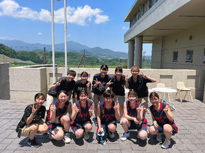 笑顔で写るユニフォーム姿の女子バスケットボール部員集合写真　小